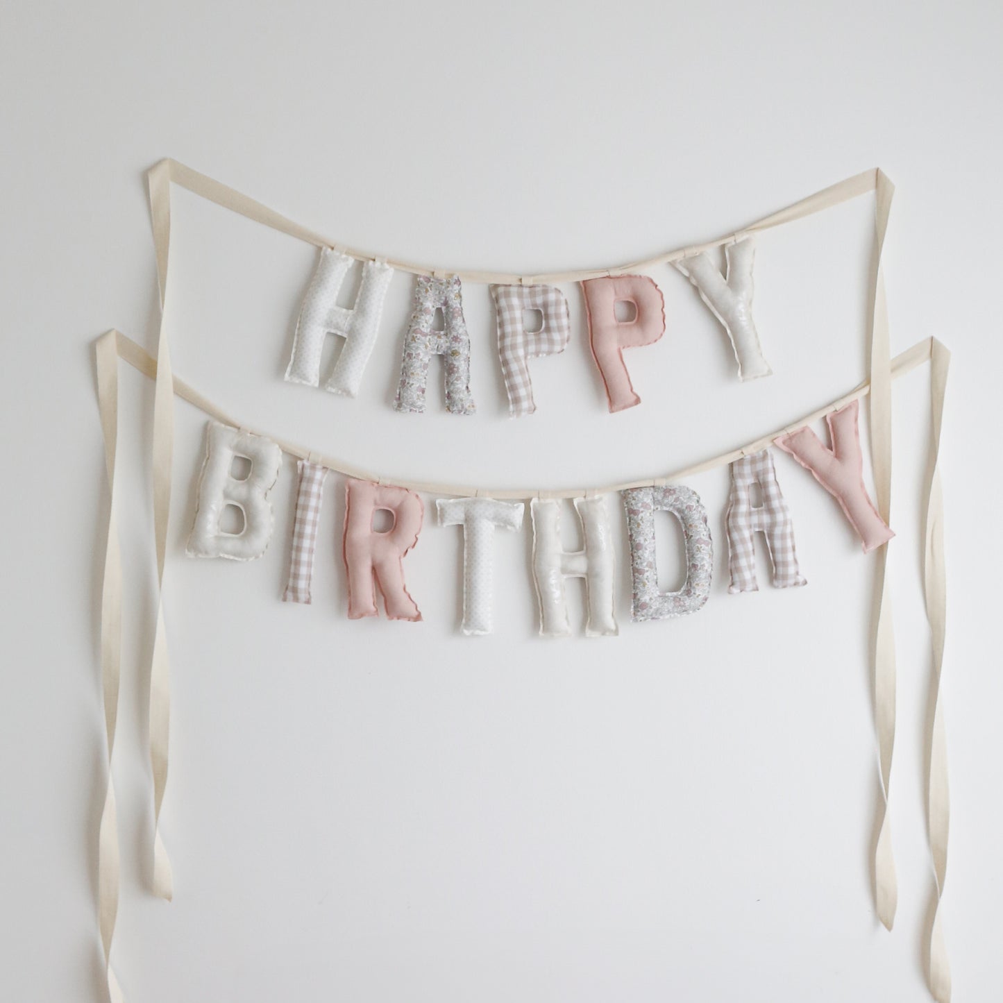 Soft pink and cream handmade ‘Happy Birthday’ fabric garland by Social Heirloom – pastel floral, gingham, and neutral cotton letters for first birthdays, nurseries, or heirloom celebrations. This palette is called Little Hearth House.