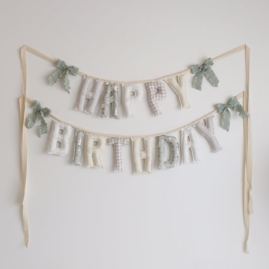 Handmade ‘Happy Birthday’ garland in soft neutral palette by Social Heirloom – features taupe gingham, floral prints, polka dots, and whimsical goose fabric, perfect for nurseries, baby birthdays, and a ‘One Silly Goose’ themed celebration