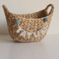 TATUM little felt garland in cream felt letters with felt balls draped over a woven basket