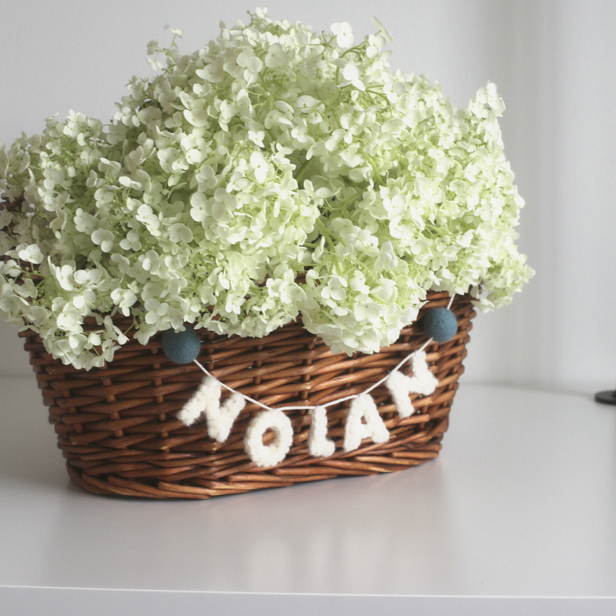 NOLAN little felt garland on a woven basket
