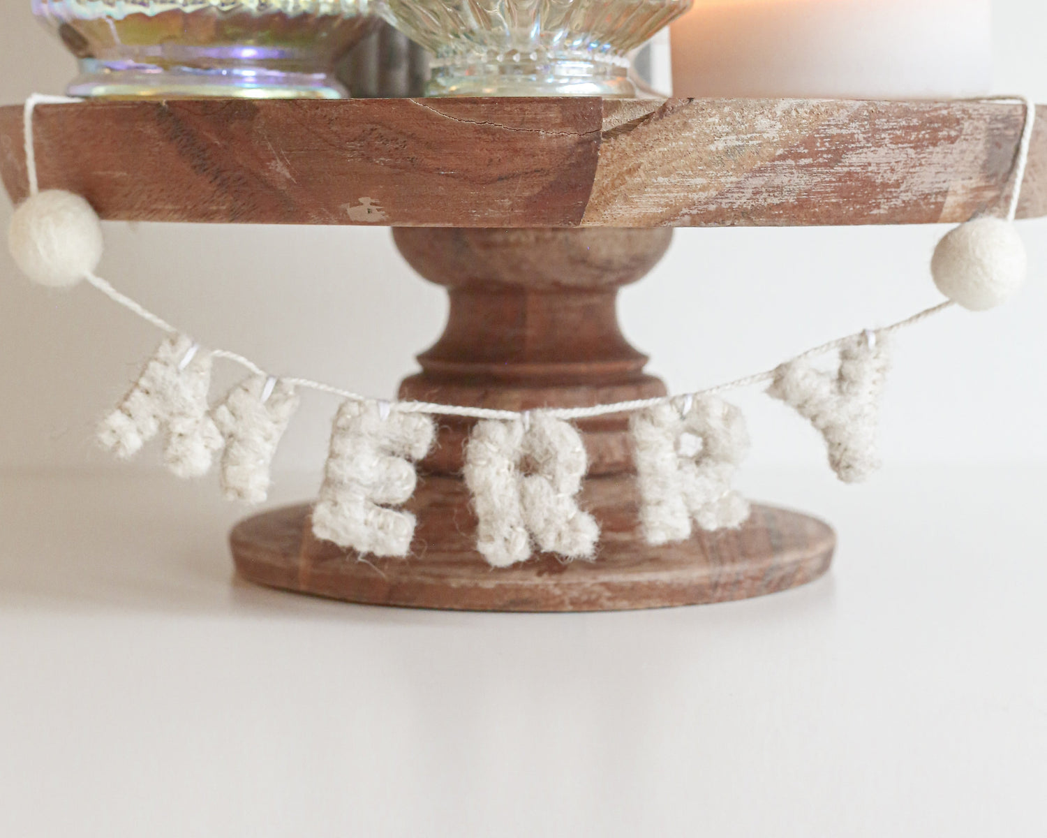 Decorative stand with Christmas tree-shaped lanterns and 'Merry' banner on a white background