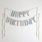 Handmade ‘Happy Birthday’ fabric garland in Salt and Sky palette – soft blue, gray, and striped cotton letters on ivory ribbon, perfect for nurseries, first birthdays, and timeless celebrations by Social Heirloom