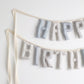 Close-up of Salt and Sky handmade birthday garland by Social Heirloom – soft cotton letters in blue, gray, and stripe patterns for heirloom birthday decor and nursery styling