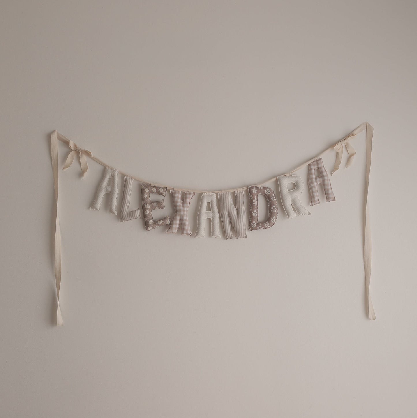 Textual decoration spelling 'ALEXANDRA' on a plain wall.