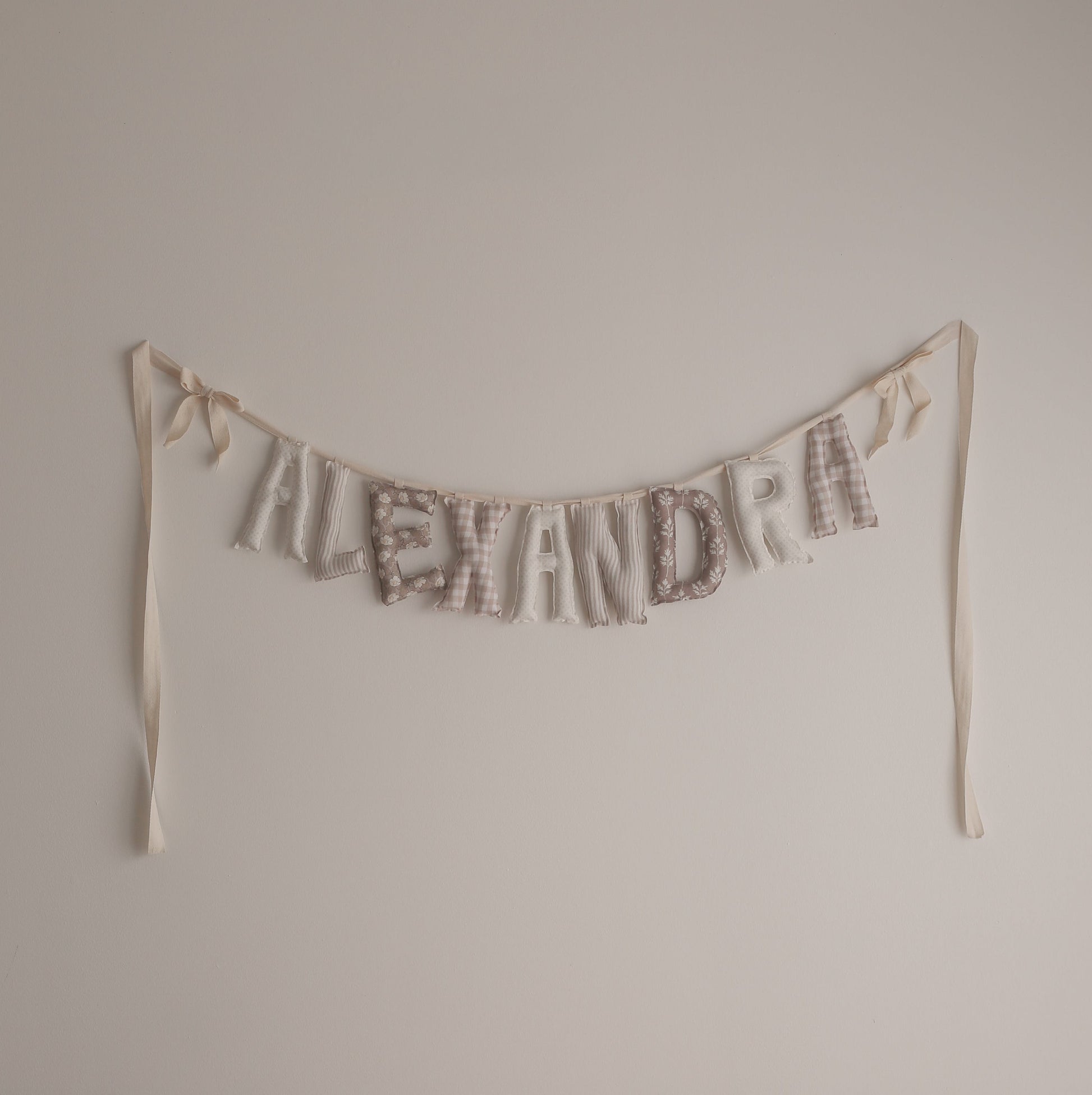 Textual decoration spelling 'ALEXANDRA' on a plain wall.