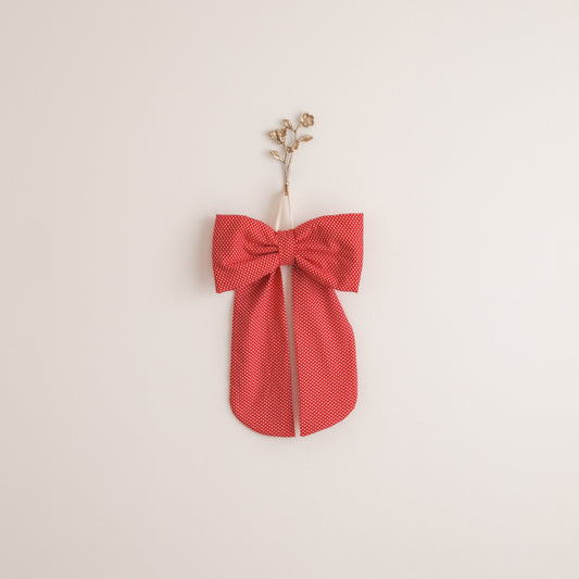 Red bow-shaped object on a beige background