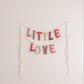 Bunting with 'LITTLE LOVE' text on a plain background