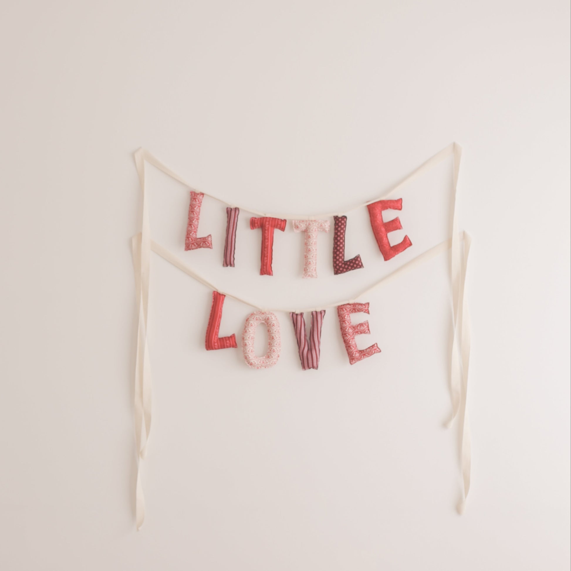Bunting with 'LITTLE LOVE' text on a plain background