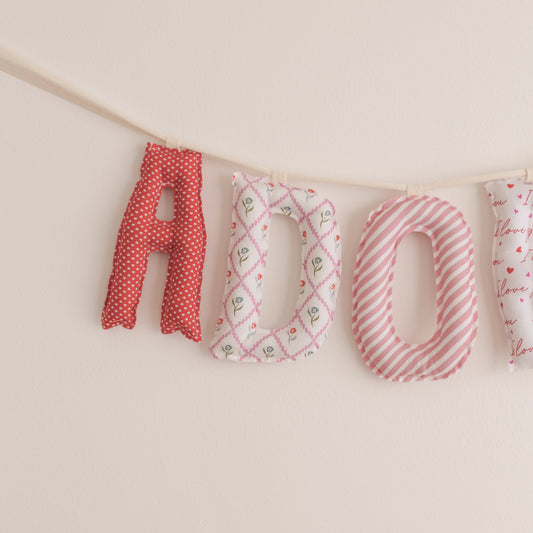 Fabric letters spelling 'LOVE' on a beige background